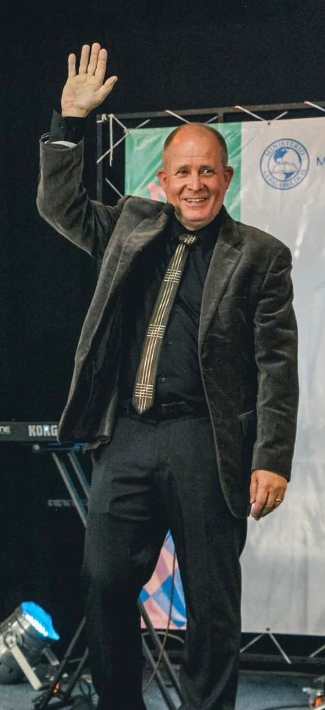 David Larson waving from the stage at La Palabra de Fe