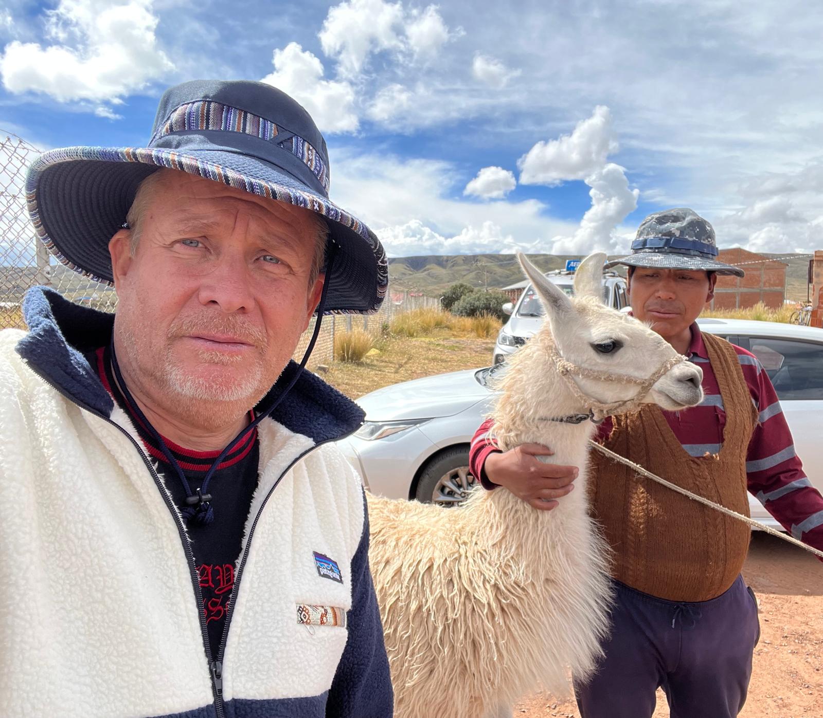 David Larson with a Bolivian friend and a llama on a clear day