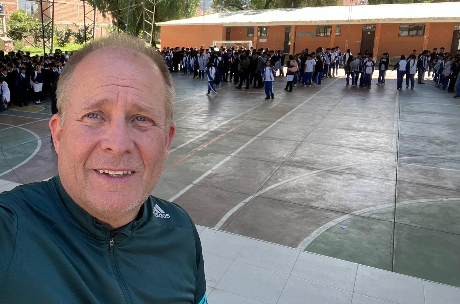 David Larson at a Bolivian school courtyard with hundreds of students
