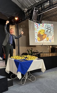 David Larson celebrating beside a table of chocolate as the church reached 22 active disciples